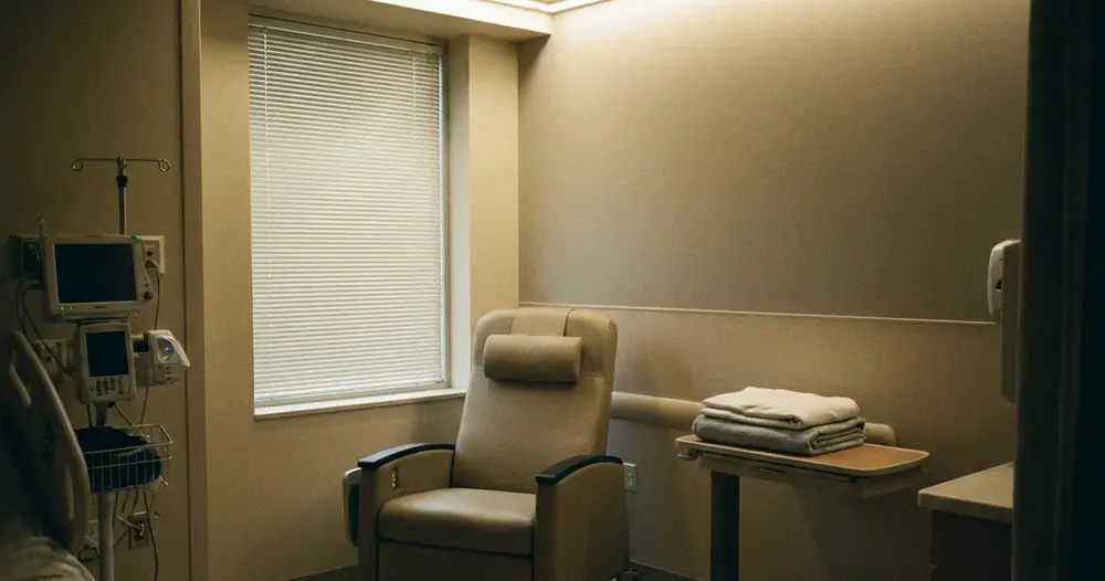 sala de recuperação hospitalar vazia com poltrona reclinável e luz suave